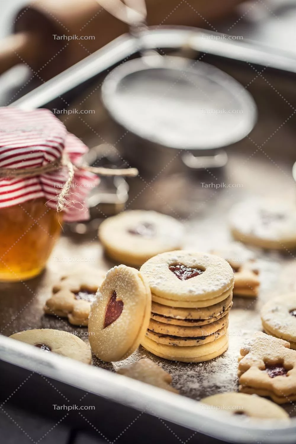 عکس شیرینی های کریسمس لینزر با مارمالاد و شکر پودری در سینی پخته شده