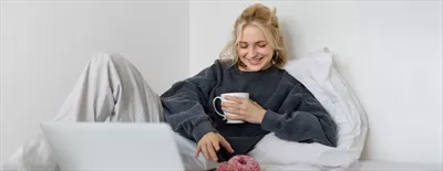 عکس پرتره ای از دختر خوشحال با موهای بلوند در حال استراحت و تماشای فیلم
