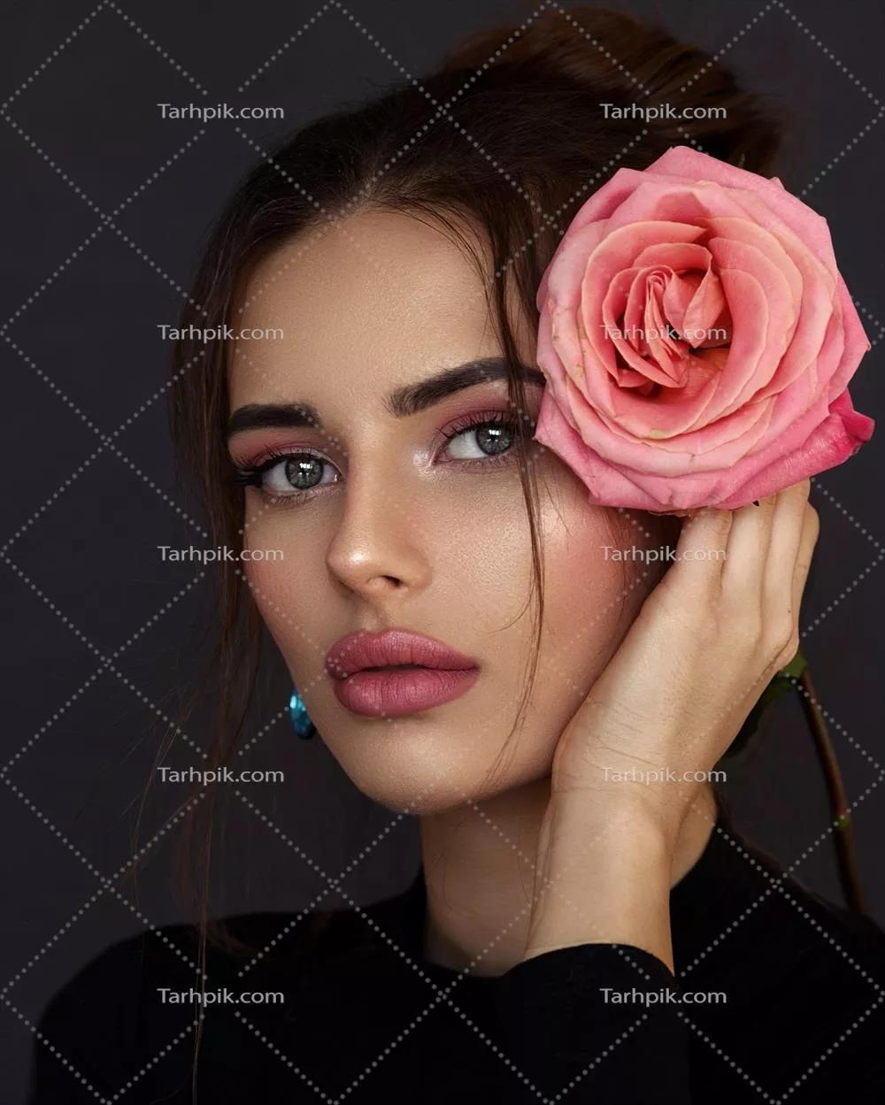 عکس دختر جوانی که با گل رز در دستش در حال لبخند زدن است