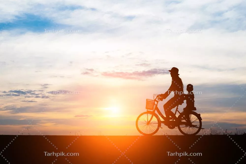 عکس مادری که در غروب آفتاب با فرزندش در حال دوچرخه سواری است