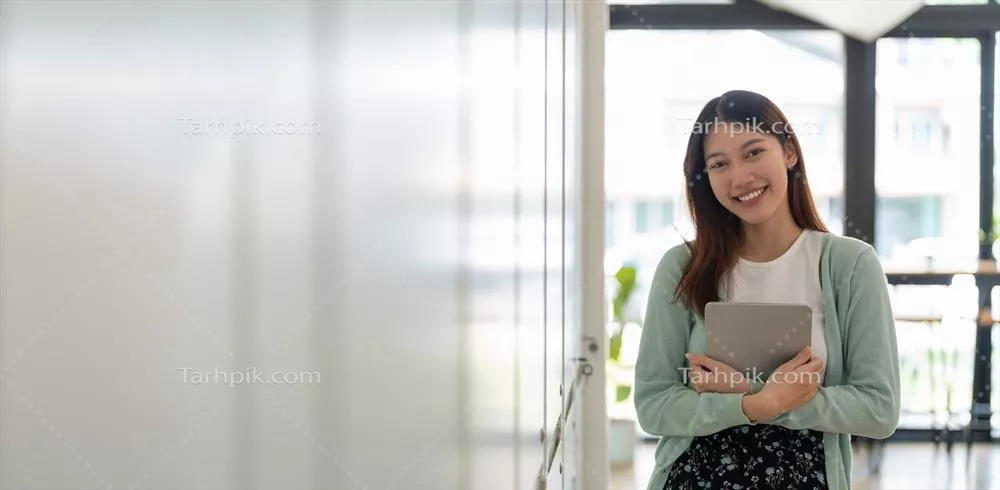 عکس پرتره ای از یک دانشجوی جوان و خوشحال آسیایی با لبخند و نگاه به دوربین