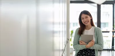 عکس پرتره ای از یک دانشجوی جوان و خوشحال آسیایی با لبخند و نگاه به دوربین