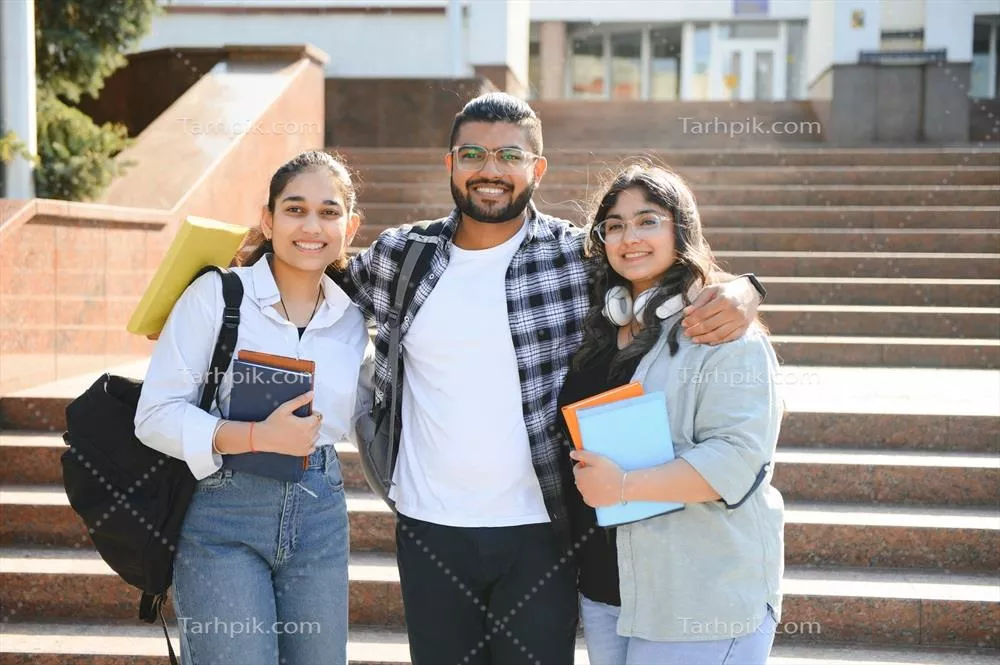عکس تصویری از سه دانشجوی چند ملیتی در دانشگاه که با هم در آغوش هم ایستاده اند