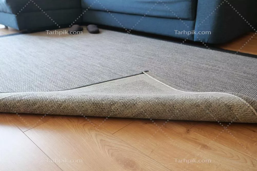 عکس بافت فرش خاکستری یکدست بر روی کف چوبی با فضای خالی برای نوشتن