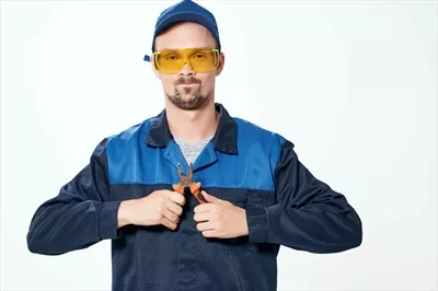 عکس کارگر ساختمانی در حال تعمیر با ابزار در محیط کار