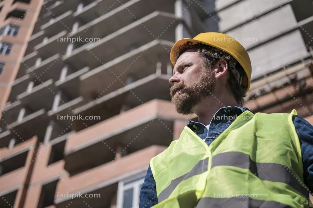 عکس سرپرست با سبیل و ریش در کلاه ایمنی زرد رنگ و با اعتماد به نفس