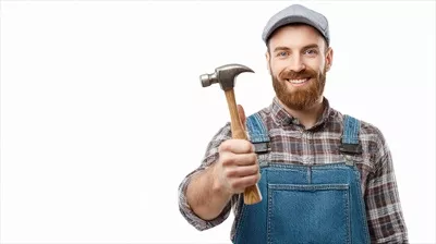 عکس مردی با ریش و لباس کار که چکش در دست دارد و آماده کار است