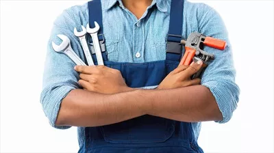 عکس مردی در لباس کار با ابزار و آچار در دست، آماده برای تعمیرات