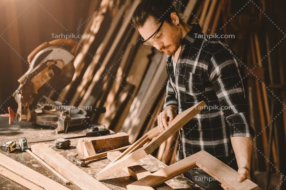 عکس کارگر چوبی مرد در کارگاه چوبی: هنر و مهارت در ساخت مبلمان چوبی