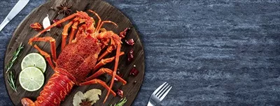 عکس لذیذترین غذاهای دریایی: خرچنگ پخته شده با چنگال و چاقو در پس زمینه سنگی