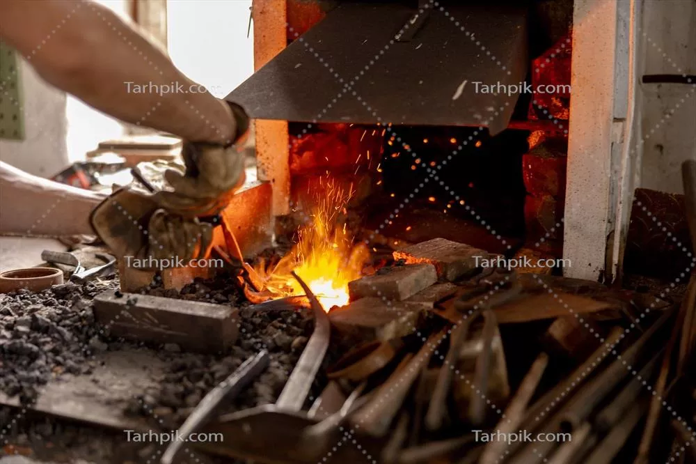 عکس فرآیند تولید محصولات فلزی توسط آهنگر در کارگاه سنتی