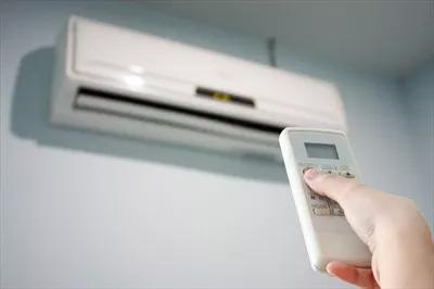 عکس کنترل از راه دور: دست بر روی کنترل دما و تهویه مطبوع