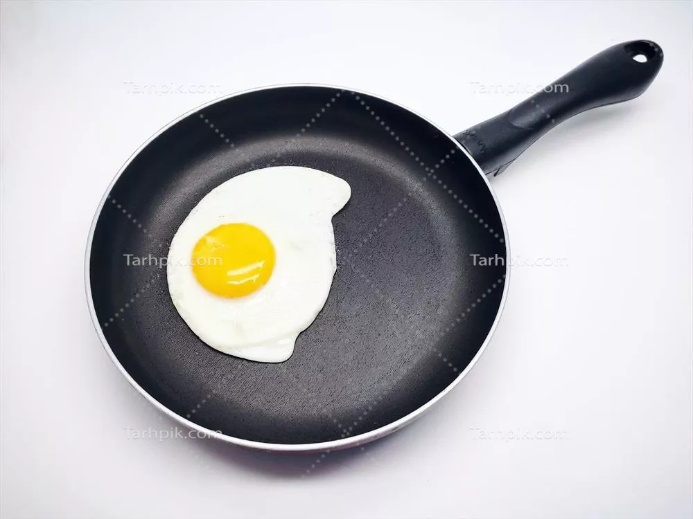 عکس تزیین تخم مرغ سرخ شده در تابه مشکی بر روی پس زمینه سفید