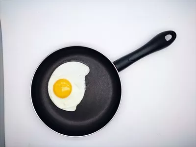 عکس تزیین تخم مرغ سرخ کرده با رنگ های جذاب در یک تابه مشکی