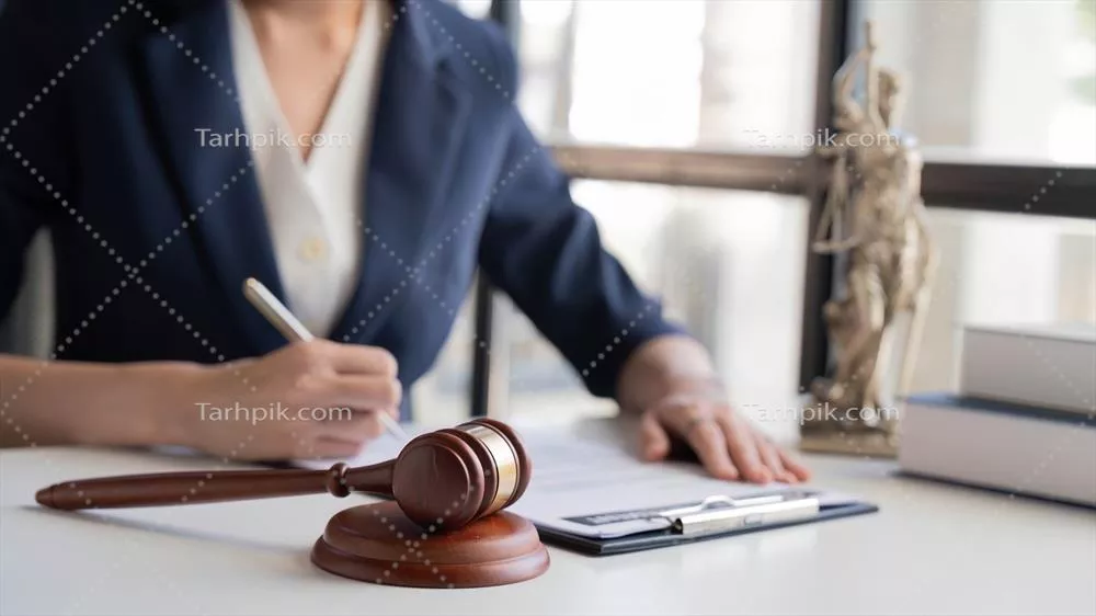 عکس وکیل زن آسیایی در حال کار با ترازوی عدالت و مطالعه کتاب حقوقی