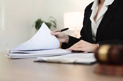 عکس وکیل زن حرفه ای در حال بررسی اسناد قانونی در یک دفتر مدرن