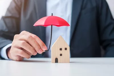 عکس مدیریت ریسک در املاک: مردی با چتر قرمز در دست، نماد امنیت مالی