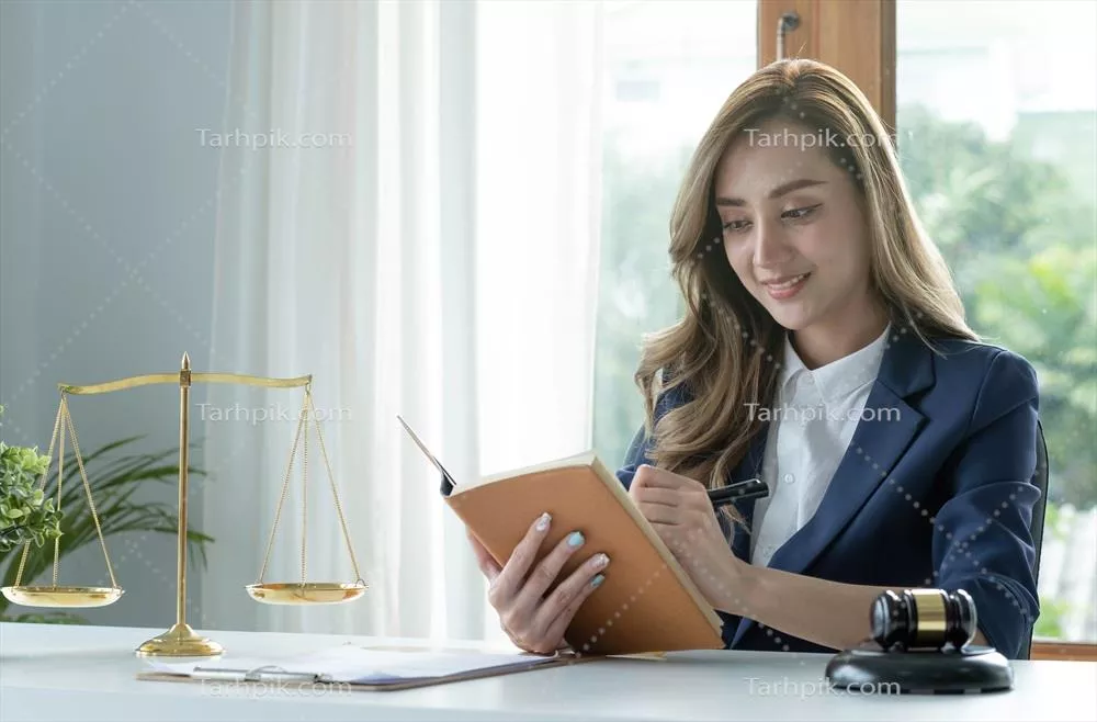 عکس زنی جوان و موفق از آسیا در حال مطالعه کتاب حقوقی در دفتر کارش
