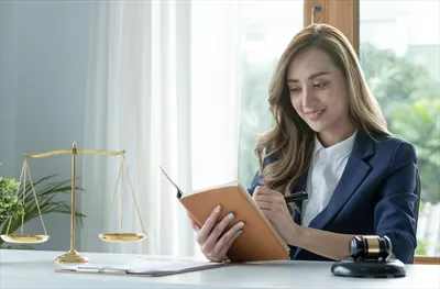 عکس زنی جوان و موفق از آسیا در حال مطالعه کتاب حقوقی در دفتر کارش
