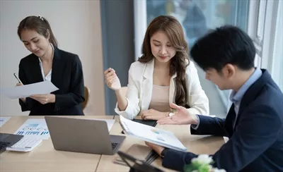 عکس گروه جوان و خلاق کسب و کار آسیایی در حال تبادل ایده ها و گفتگو