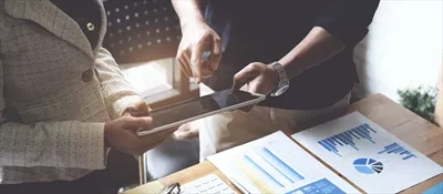 عکس گروهی از بازرگانان و حسابداران در حال بررسی فساد مالی با تبلت دیجیتال