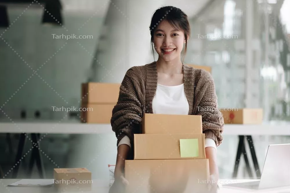 عکس زنی جوان و شاد آسیایی در حال راه اندازی کسب وکار کوچک و فریلنسری