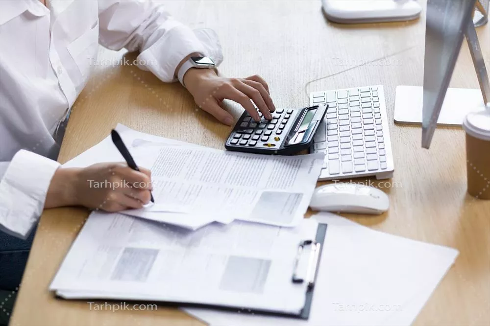 عکس نزدیک نمایی از دست یک زن کارآفرین بر روی مدارک مالی و حسابداری