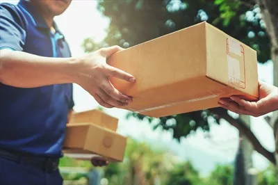 عکس تحویل دهنده در حال ارائه بسته به مشتری با دقت و حرفه ای