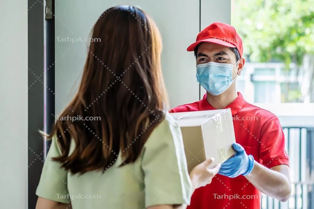 عکس تحویل دهنده ای در یونیفورم قرمز که بسته ها را به مشتری زن تحویل می دهد