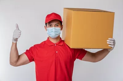 عکس یک پیک جوان آگاه با کلاه قرمز و لباس ساده در پس زمینه خاکستری