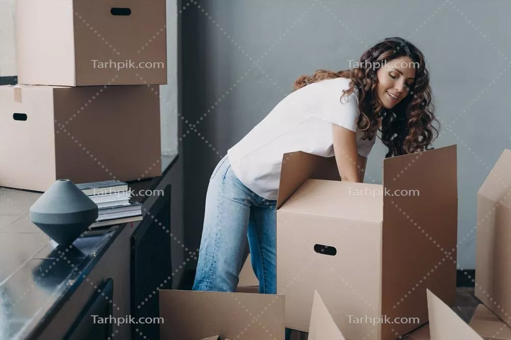 عکس زن هیسپانیک در حال باز کردن جعبه ها در خانه جدید خود در حین جابجایی