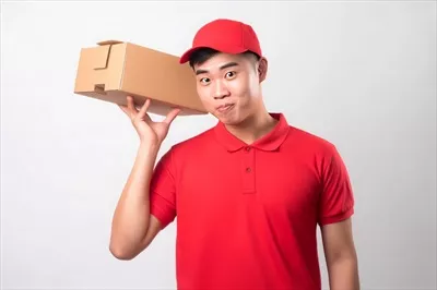 عکس تصویری جذاب از یک پسر جوان چینی با لباس تحویل غذا