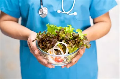 عکس متخصص تغذیه در حال ارائه مشاوره با سبزیجات تازه و سالم