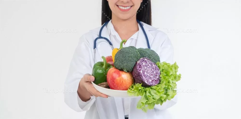عکس متخصص تغذیه با میوه های تازه در کلینیک، نماد سلامتی و رژیم غذایی مناسب