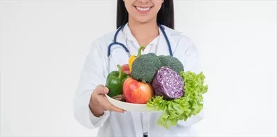 عکس متخصص تغذیه با میوه های تازه در کلینیک، نماد سلامتی و رژیم غذایی مناسب