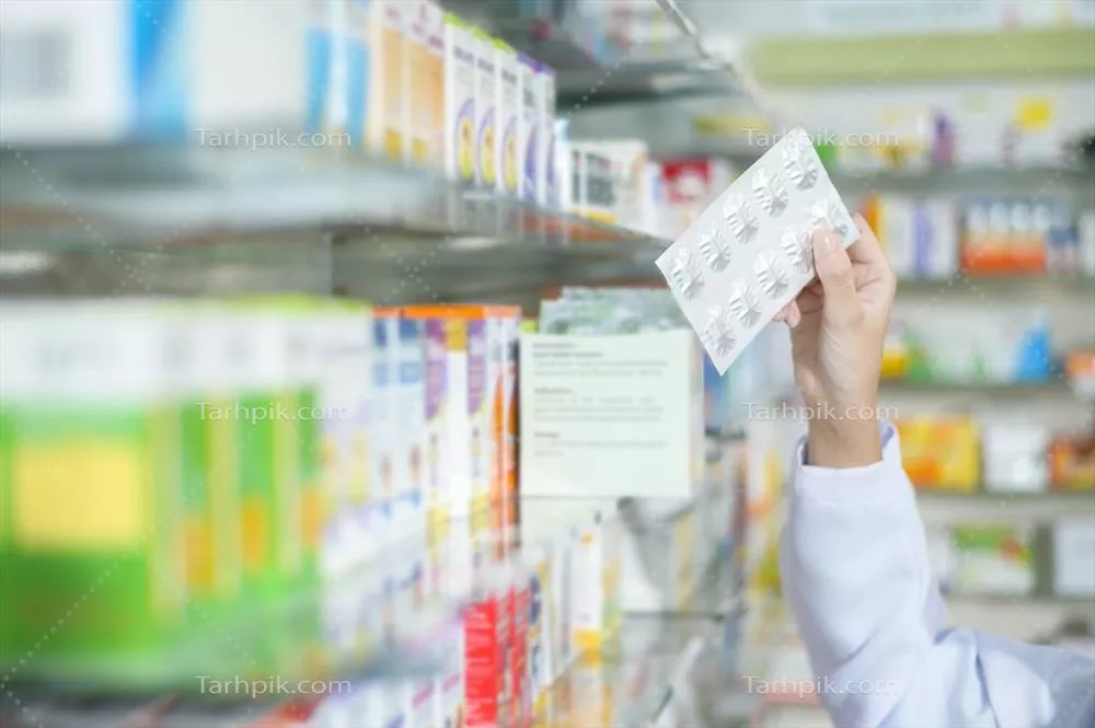 عکس داروساز زن در حال انتخاب دارو برای مشتری در داروخانه مدرن