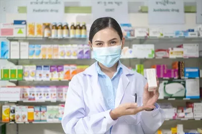 عکس پرتره ای از داروساز زن با ماسک در داروخانه ای مدرن و شیک