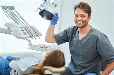 عکس ملاقات دندانپزشک مرد با بیمار زن در مطب دندانپزشکی