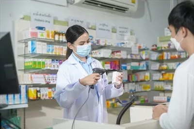 عکس پرتره ای از یک داروساز زن با ماسک در داروخانه ای مدرن و شیک