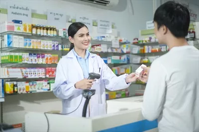 عکس مشاوره داروساز زن به مشتری درباره استفاده از داروها در داروخانه مدرن