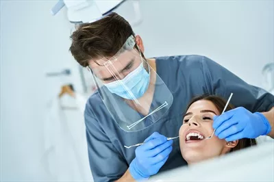 عکس ملاقات دندانپزشک مرد با بیمار زن در مطب دندانپزشکی
