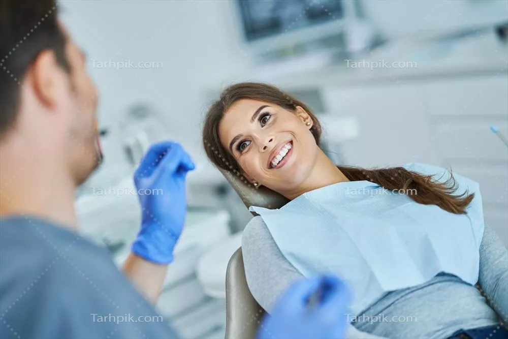 عکس ملاقات دندانپزشک مرد با بیمار زن در مطب دندانپزشکی