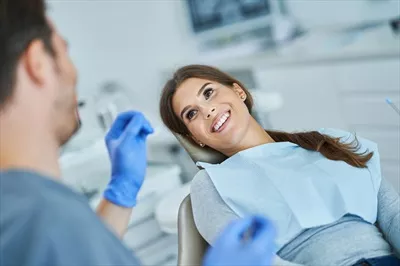 عکس ملاقات دندانپزشک مرد با بیمار زن در مطب دندانپزشکی