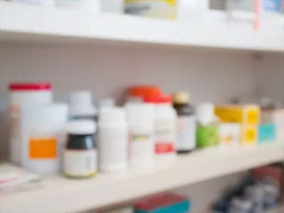 عکس نمای نزدیک از بطری های دارویی در قفسه های داروخانه