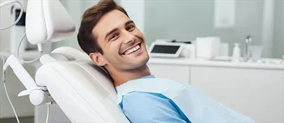 عکس مرد جوان در حال دریافت خدمات دندانپزشکی در یک محیط خالی