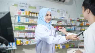عکس مشاوره دارویی یک داروساز مسلمان زن در داروخانه مدرن