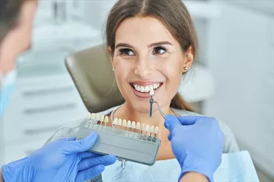 عکس انتخاب رنگ دندان توسط زن و دندانپزشک مرد در مطب دندانپزشکی