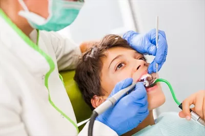 عکس کودکی که در مطب دندانپزشکی منتظر درمان است و احساس نگرانی می کند