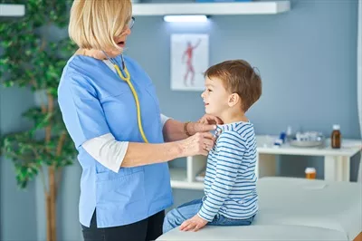 عکس پزشک اطفال در حال معاینه کودکان کوچک در کلینیک به صورت حرفه ای