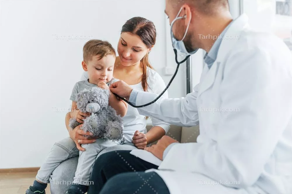عکس پسر کوچک در حال معاینه توسط دو پزشک در کلینیک پزشکی